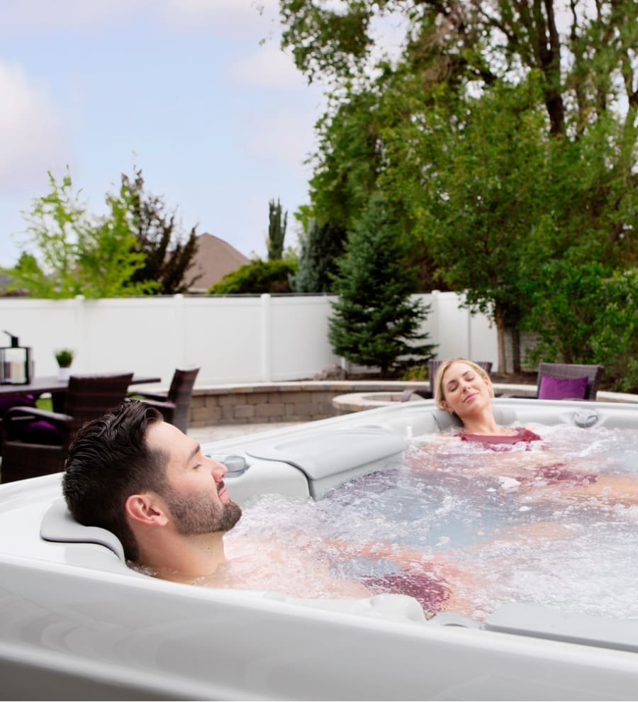 Two people are relaxing in a hot tub.